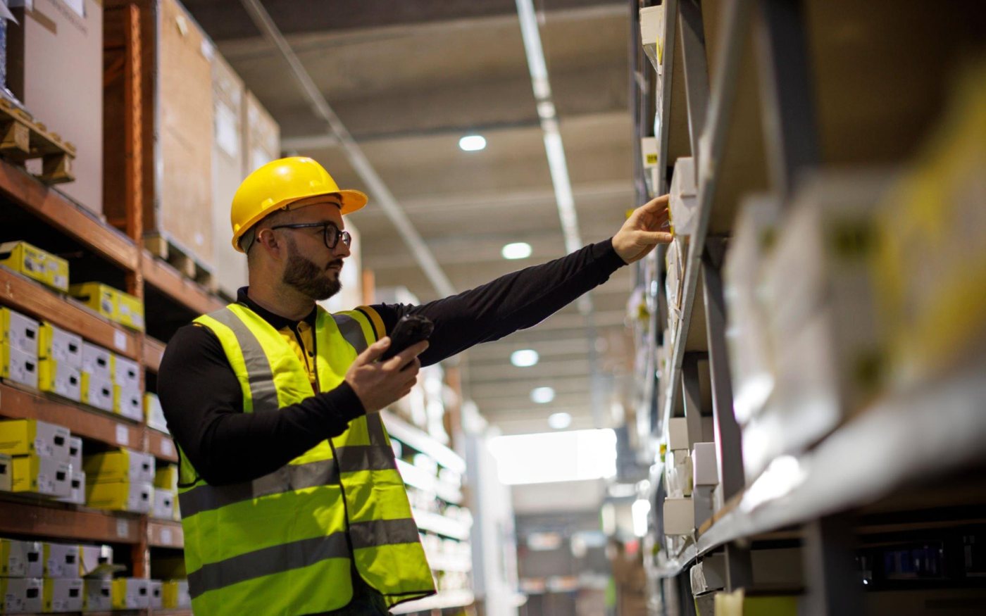 Warehouse operative checking stock locations against the inventory system